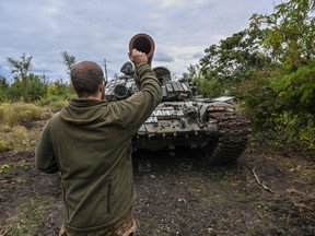 A Ukranian soldier inspects a captured Russian tank on the outskirts of Izyum, Kharkiv Region, eastern Ukraine on Sept.14, 2022.