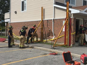 Ottawa Fire Services structural collapse technicians work on a three-storey townhouse that was struck by a vehicle on Friday afternoon.