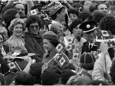 Canadian flags wave as Queen Elizabeth II and Prince Philip walk through the crowd estimated at 100,000 in Ottawa, Ont. April 17, 1982 to witness the signing of a historic proclamation giving Canada independence from Britain.