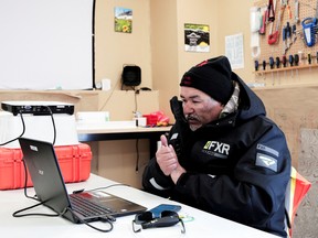 Rex Holwell, 47, checks Siku, an app used to share the sea ice thickness with community members, to make sure the data recorded during his SmartKAMUTIK run was uploaded correctly, in Nain, Newfoundland and Labrador.