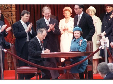 Queen Elizabeth II signs Canada's constitutional proclamation in Ottawa on April 17, 1982 as Prime Minister Pierre Trudeau looks on.