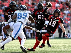 Ottawa Redblacks quarterback Nick Arbuckle (19) falls as he attempts to throw the ball as he is rushed by Toronto Argonauts defensive lineman Brandon Barlow (95) during second half CFL football action in Ottawa on Saturday, Sept. 10, 2022.