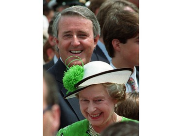 Queen Elizabeth II and Prime Minister Brian Mulroney smile as they make their way by people gathered on Parliament Hill for Canada Day celebrations in Ottawa, July 1, 1990.