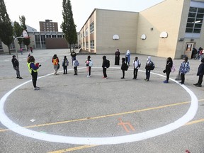 Children wait in a physical distancing circle at Portage Trail Community School, which is part of the Toronto District School Board (TDSB), during the COVID-19 pandemic in Toronto on Tuesday, Sept. 15, 2020.