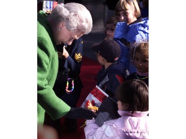 Queen Elizabeth II accepts flowers from some children following a tree planting ceremony at Rideau Hall in Ottawa, October 13, 2002.