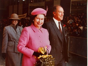 Queen Elizabeth II and Prime Minister Pierre Trudeau walk out of a hangar at the Ottawa airport to their waiting limos after the monarch arrived in Ottawa for the signing of the Constitution in 1982.