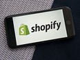 The Shopify Inc. logo displayed on a smartphone.