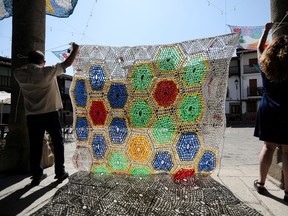 Founder of "Weaving the Streets" project, Marina Fernandez Ramos and her father Manuel, put on display one of the canopies made of recycled material to protect people from the intense summer heat in Valverde de la Vera, in the province of Caceres, Spain, August 26, 2022.