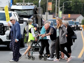 Upwards of 100 local seniors and residents took to two intersections in downtown Manotick Wednesday to protest the volume of heavy trucks that roar through the small village on a daily basis.
