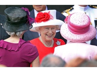 Queen Elizabeth is all smiles as she leaves the stage at the end of the noon hour festivities and greets well wishers, many wearing hats, who have a coveted spot on Parliament Hill for Canada Day, July 1, 2010.