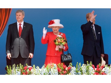 Queen Elizabeth and Prince Philip (right) are joined by Prime Minister Stephen Harper (L) on stage on Parliament Hill for the noon hour festivities for Canada Day, July 1, 2010.