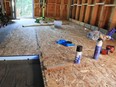 Insulating from the top is the best way to add R value to floors over unheated spaces. Here two inches of extruded polystyrene foam sits on a plywood subfloor with OSB on top. Finished flooring sits on the foam and wood.