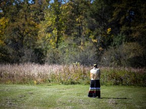 Before the powwow, a woman stood alone in the field.