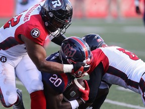 Montreal Alouettes running back Jeshrun Antwi (20) his tackled by Avery Williams (42) of the Ottawa Redblacks, during second half CFL action in Montreal on Monday, Oct. 10, 2022.