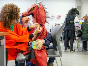 Four-year-old Édouard Poulin received a vaccination while dressed like a dragon at the kids Halloween-themed event at a centre in Gatineau on Saturday.