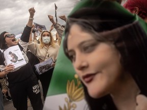 ISTANBUL, Turkey — People chant slogans during a protest against the death of Iranian Mahsa Amini (whose image is seen at right). Amini died after being arrested in Tehran by the morality police, for allegedly violating the country’s hijab rules.