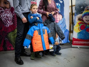 Six-year-old Ostap Stankevych with his parents Andriy and Nataliia and his four-year-old brother Zakhar. The family of Ukrainian refugees were at the campaign launch receiving new snowsuits for the kids. Nataliia didn’t know much about Canada before relocating here this summer but said “we feel like we are at home” after her children were given their new snowsuits.