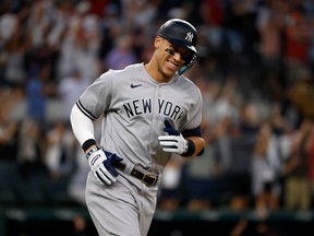 Aaron Judge #99 of the New York Yankees smiles as he rounds the bases after hitting his 62nd home run of the season against the Texas Rangers during the first inning in game two of a double header at Globe Life Field on October 4, 2022 in Arlington, Texas.