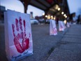 The sun begins to set as candlelight vigil organizers begin to remove paper bags, adorned with the names of missing and murdered Indigenous women and girls, from Belleville's Market square.