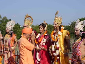 Uttar Pradesh state Chief Minister Yogi Adityanath greets artists dressed as Hindu god Ram, goddess Sita and Lakshman on the banks of river Saryu on the eve of Diwali, the Hindu festival of lights, in Ayodhya, India. Sunday, Oct. 23, 2022.
