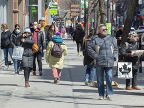 Pedestrians walk down St. Catherine street Monday April 6, 2020 in Montreal.