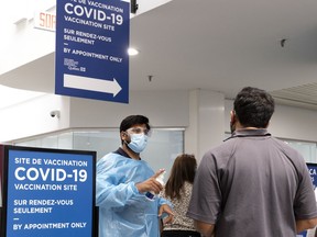 A greeter meets people arriving at the Décarie Square COVID-19 vaccination centre in 2021.