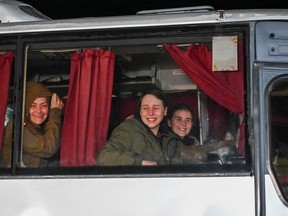 Relieved Ukrainian female prisoners of war (PoWs) look out of a bus window as they arrive in Zaporizhzhia, Ukraine on Oct. 17. REUTERS/Stringer