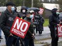 Residents of North Grenville carry 'No Jail' signs as they protest at the site of a proposed correctional facility in 2021. 