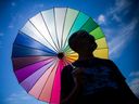 A man holds a coloured parasol representing inclusivity.