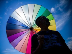 A man holds a colored parasol representing inclusivity.