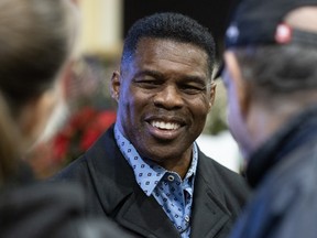 Republican Senate nominee Herschel Walker talks with supporters during a rally on Nov. 21, 2022 in Milton, Georgia.