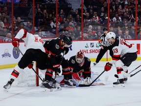 Ottawa Senators defenCeman Artem Zub (2) defends against New Jersey Devils right wing Nathan Bastian (14) and center Nico Hischier (13) in front of goaltender Cam Talbot (33) during second period NHL action at the Canadian Tire Centre on Saturday, Nov. 19, 2022.