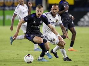 CF Montreal defender Alistair Johnston, left, takes the ball away from LA Galaxy midfielder Victor Vazquez during the second half of an MLS soccer match in Carson, Calif., on July 4, 2022.