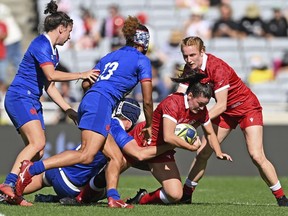 Canada's Alysha Corrigan, second right, is supported by teammate Maddy Grant as France's Maelle Filopon, second left, comes in to help in the tackle in the bronze medal game of the women's rugby World Cup at Eden Park in Auckland, New Zealand, Saturday, Nov.12, 2022. The Canadian women return home from the Rugby World Cup proud but disappointed after a tournament that saw them impress prior to running into a classy French side in the bronze-medal match.THE CANADIAN PRESS/AP, Photosport, Andrew Cornaga