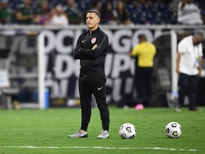 (FILES) In this file photo taken on July 29, 2021 Canada's head coach John Herdman watches the field ahead of the Concacaf Gold Cup football match semifinal between Mexico and Canada at NRG stadium in Houston, Texas.