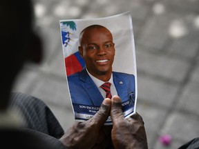 A person holds a photo of late Haitian president Jovenel Moïse during his memorial ceremony at the National Pantheon Museum in Port-au-Prince, Haiti, Tuesday, July 20, 2021. The RCMP says a Lévis, Que., man is facing terrorism charges stemming from allegations he planned a terrorist act to overthrow the Moïse government and take power.