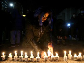 About a hundred people came out for a candlelight vigil at the Human Rights Monument in downtown Ottawa Thursday night to grieve and remember those killed in the recent Club Q shooting in Colorado Springs. Local drag queen Aimee Yonce leaves a candle at the foot of the monument.