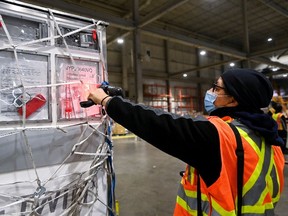 A FedEx workers scans a shipment carrying 255,600 doses of the Moderna COVID-19 vaccine at Pearson International Airport in Toronto on March 24, 2021.