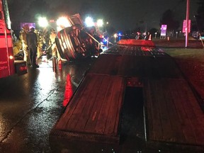 Firefighters work to rescue a driver from a car that flipped after striking a truck's flatbed ramp Friday, Nov. 11