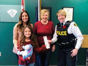 Young Piper, eight, found a valuable ring in her trick or treat bag, Behind her is her mom, Catherine Denis-Berniqué.and Diane Swanson, owner of the ring, is at centre. At right is OPP Hawkesbury detachment Staff-Sgt. Anne Christine Gauthier.