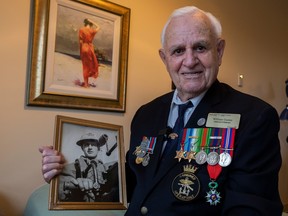 Second World War veteran Bill Gunter, 97, holds a photo of himself as a young man in the Royal Canadian Navy.