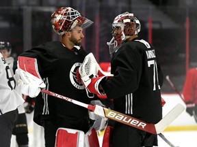 Ottawa Senators goaltender Cam Talbot (33) taps goaltender Kevin Mandolese (70) with his stick as they greet each other during the team's training camp in Ottawa, on Sept. 22, 2022.