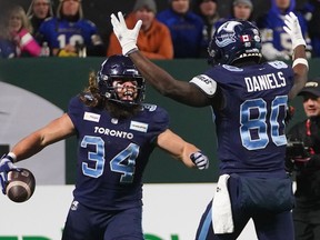 Toronto Argonauts running back AJ Ouellette (34) celebrates his touchdown with wide receiver DaVaris Daniels (80) during second half football action against the Winnipeg Blue Bombers in the 109th Grey Cup at Mosaic Stadium in Regina, Sunday, Nov. 20, 2022. Ouellette's five-yard touchdown run in the fourth quarter rallied the Toronto Argonauts to a stirring 24-23 upset of the Winnipeg Blue Bombers in the 109th Grey Cup on Sunday night.