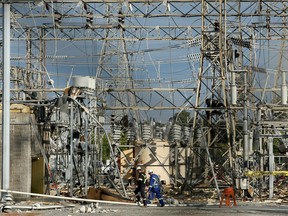 A file photo shows workers inspecting the damage done to the Merivale Transformer Station by tornadoes in September 2018.