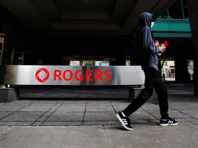 A person walks near the Rogers Communications Inc. building in Toronto.
