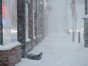 A homeless man sits in the snow on Elgin Street during one of last winter's major storms.
