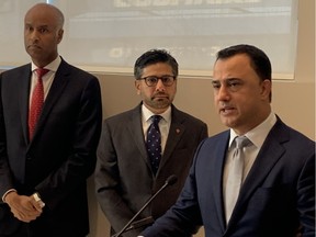 Ontario Associate Minister of Housing Michael Parsa speaks in Ottawa Tuesaday while federal Housing Minister Ahmed Hussen (left) and Ottawa Centre MPP Yasir Naqvi look on.