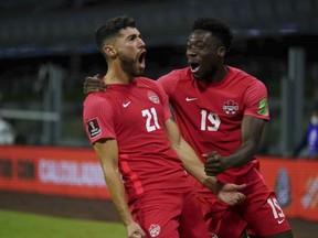 Canada's Jonathan Osorio, left, celebrates with teammate Alphonso Davies after scoring his side's first goal against Mexico during a qualifying soccer match for the FIFA World Cup Qatar 2022, at Azteca stadium in Mexico City, Thursday, Oct. 7, 2021. Osorio's road to the World Cup has not been without its bumps, not to mention a stop in Uruguay.