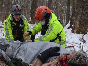 Pierluc Seguin, left, and Kate Van of Ottawa Volunteer Search and Rescue tend to an “injured” hiker during a training exercise. Blair Crawford/Postmedia