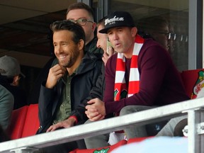 Actors Ryan Reynolds and Rob McElhenney watch their Wrexham AFC side play Torquay in October 2021 at the Racecourse Grounds in Wrexham, Wales.